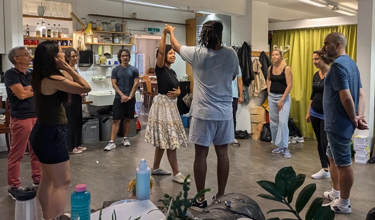 Guilherme and Marília demonstrating a move in the middle of a circle of students